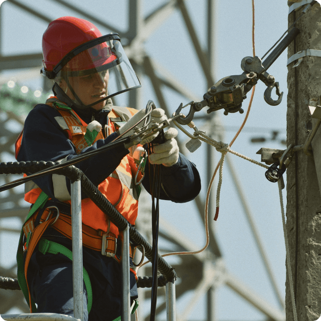 Female industrial worker with safety gear connecting cables