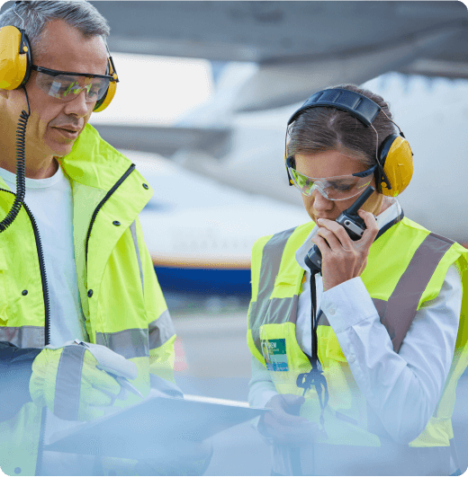 A man and a woman collaboratively working on the airport grounds. They are engaged in tasks that contribute to the efficient operation of the airport, possibly checking equipment, coordinating logistics, or ensuring the smooth functioning of airport operations.