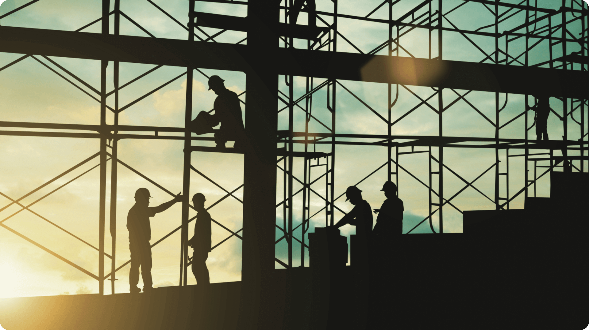 industrial workers in scaffolding at sunset