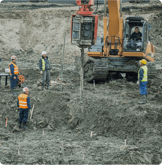 Workers beside an excavator working in mining