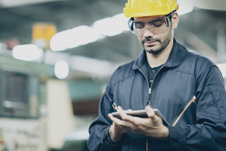 An onsite worker verifies contract compliance on a mobile device.