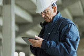 Worker leveraging compliance software to increase safety on the job site.